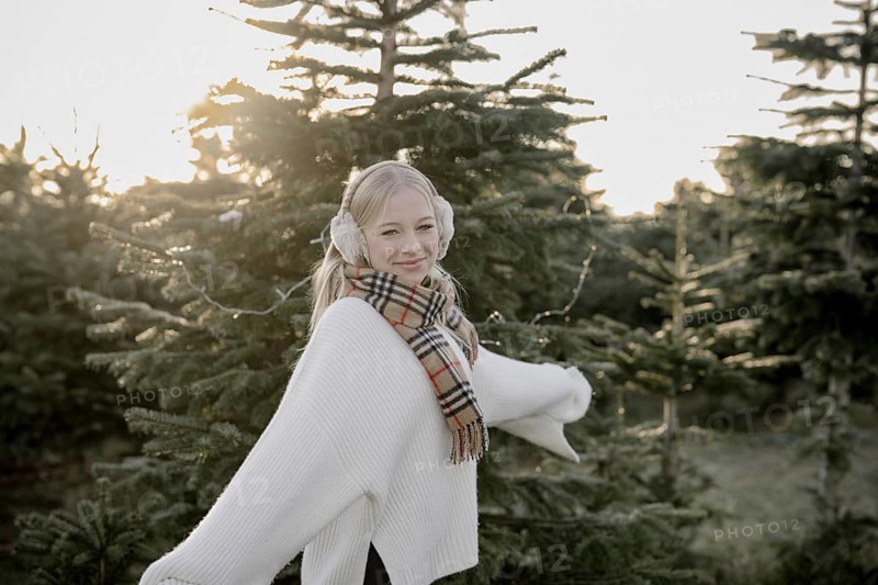 Teenage girl in front of fir trees