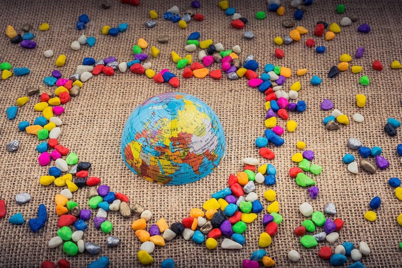 Globe in the heart form shaped by colorful pebbles