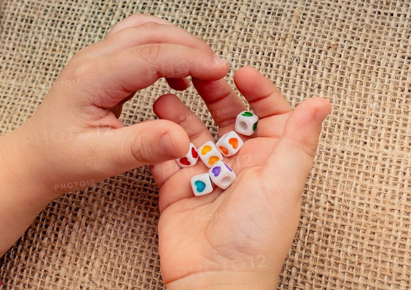 Little cubes with heart shape in hand on canvas