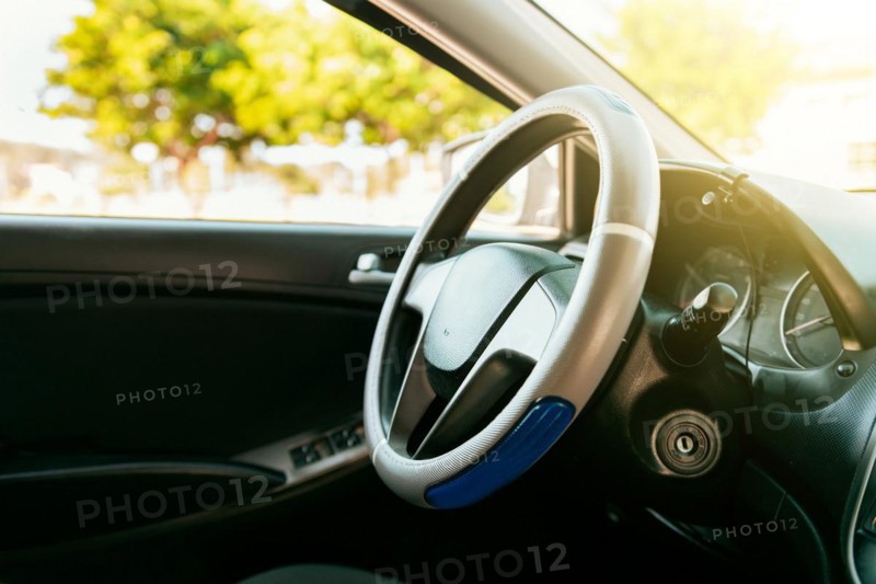 Close up of car steering wheel. Side view of a car steering wheel. A car wheel with copy space