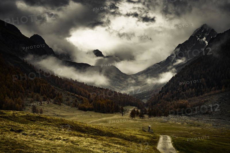 Way cross with path in autumnal mountain landscape with threatening cloudy sky