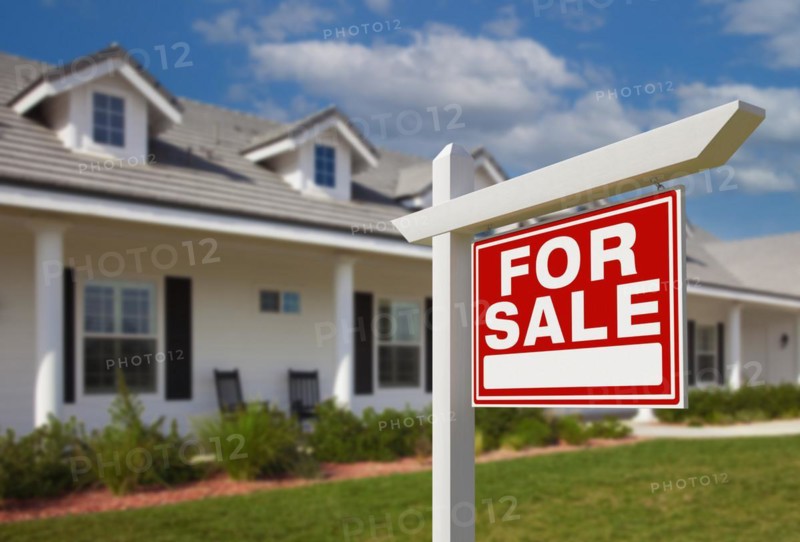 For sale real estate sign in front of new house