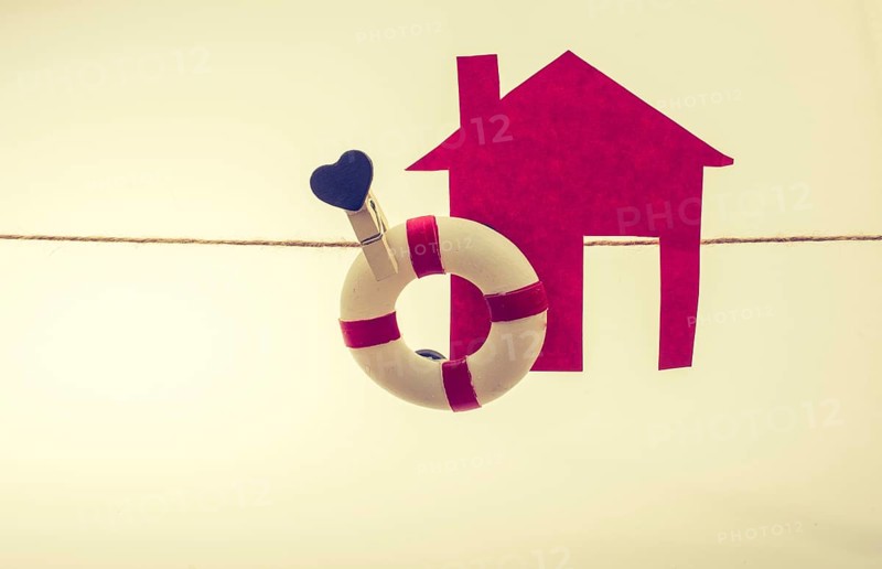 Model house and a life preserver with a heart on a string