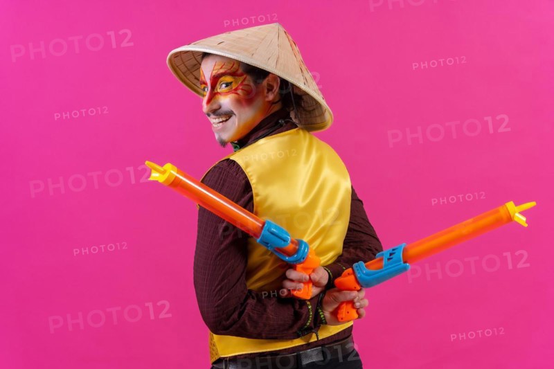 Portrait of a clown with white facial makeup on a pink background