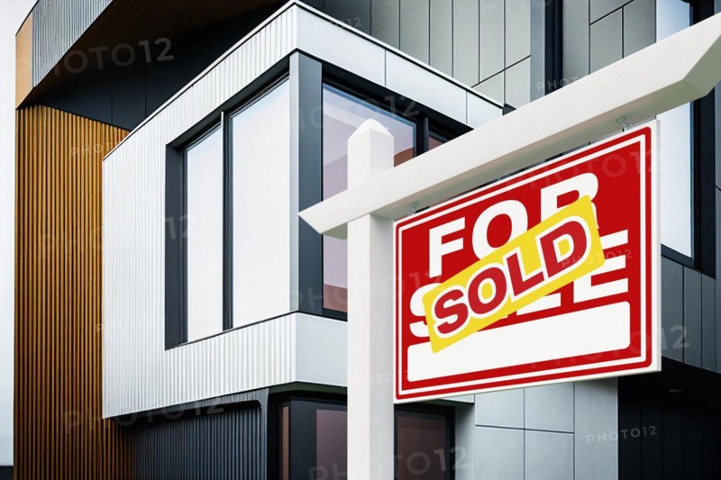 Sold real estate sign in front of new contemporary house