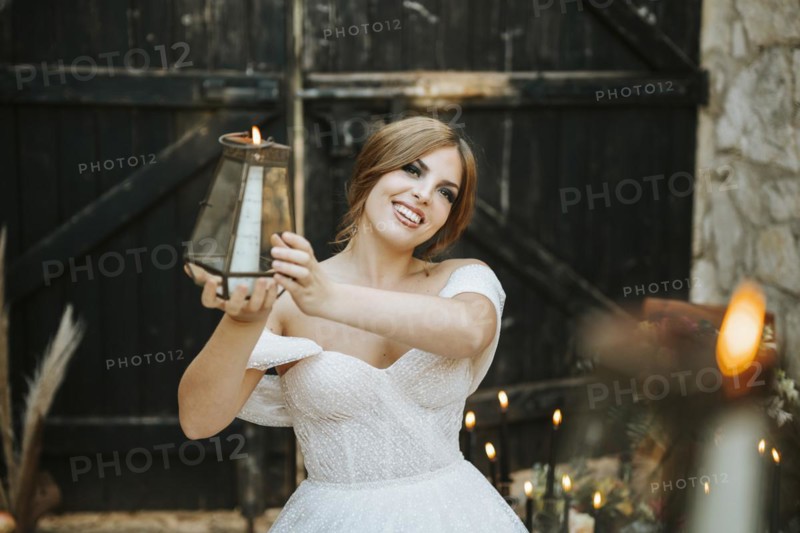 Portrait of beautiful bride holding lantern in rustic background
