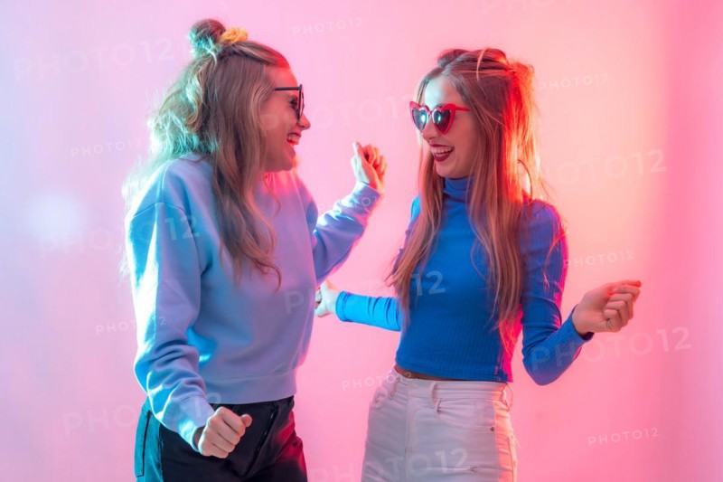 Two young blonde caucasian women dancing in nightclub