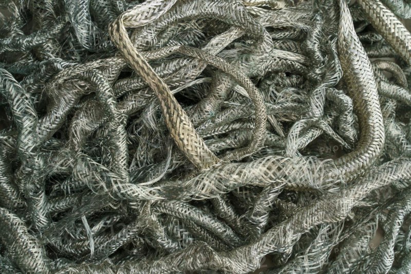 Silver metal copper wire scrap materials recycling of waste from manual wire tearing. Closeup of copper waste in the form of copper wires