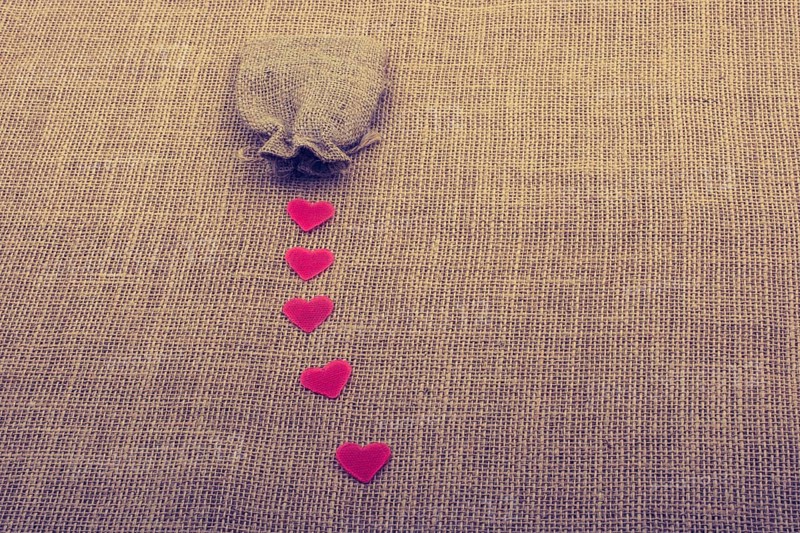 Heart shaped objects before a sack on canvas