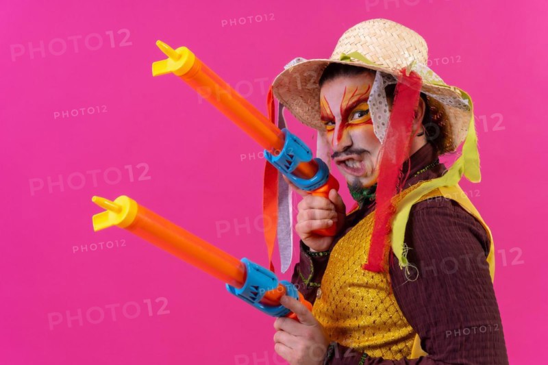 Juggler with white facial makeup on a pink background