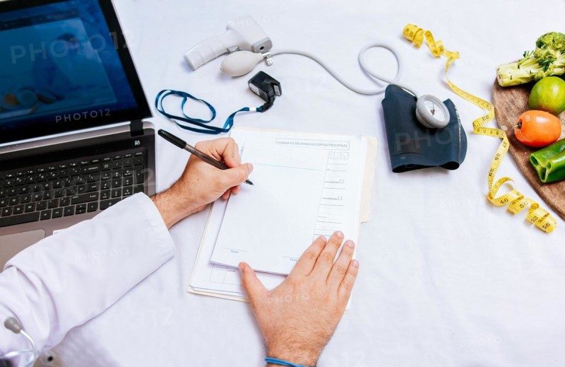Top view of nutritionist writing on notepad. Concept of nutritionist taking notes on prescription