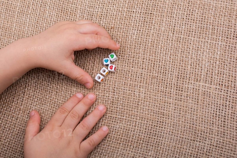 Little cubes with heart shape in hand on canvas