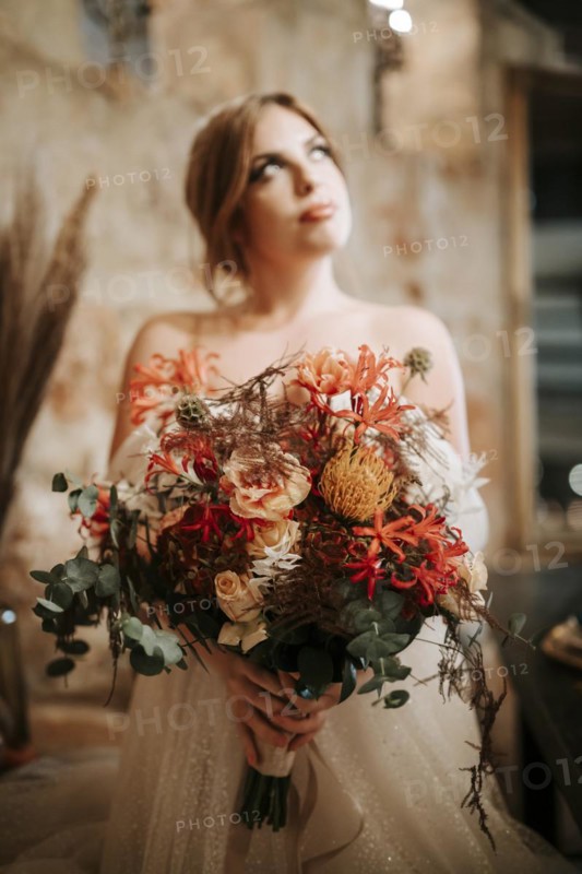 Portrait of beautiful bride with a bouquet in rustic settings