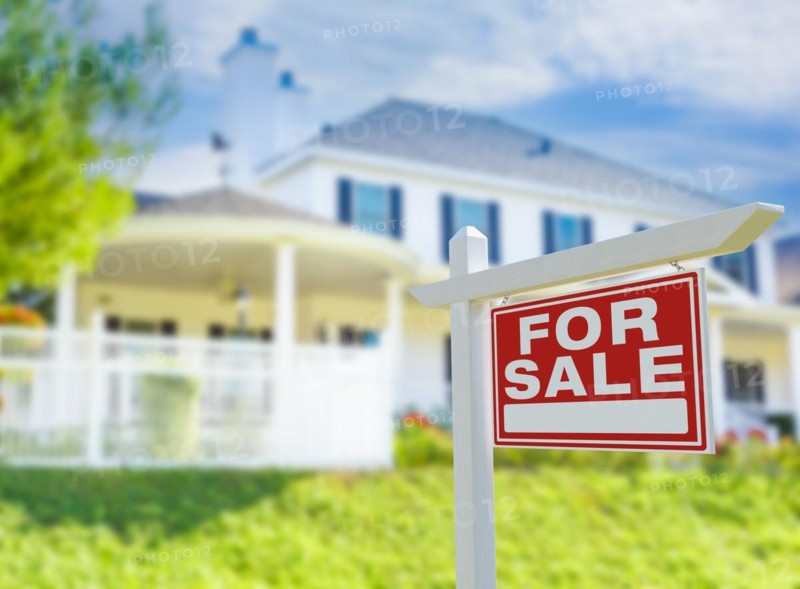 For sale real estate sign in front of new house