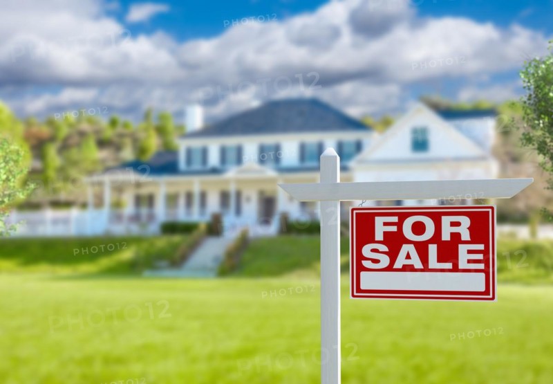 For sale real estate sign in front of new house