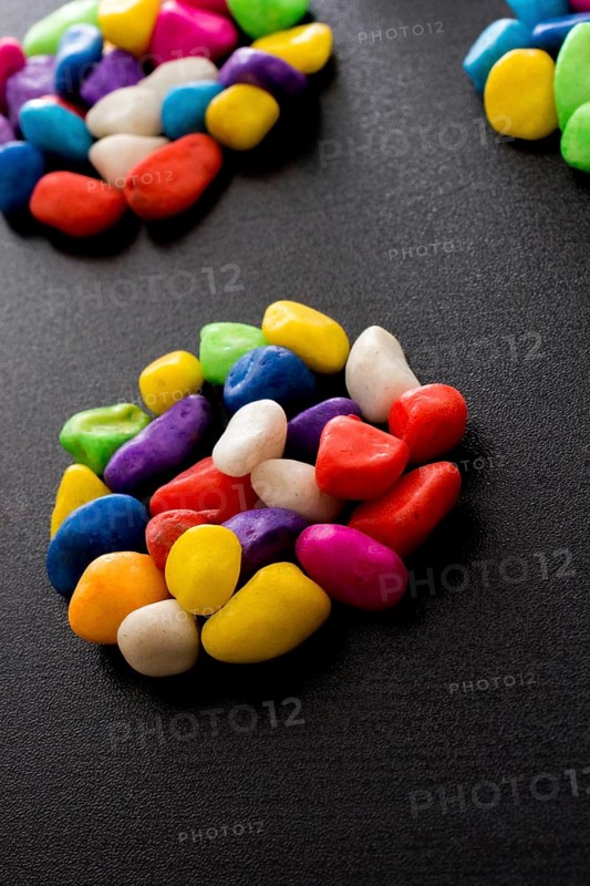 Pile of little colorful pebbles on black background
