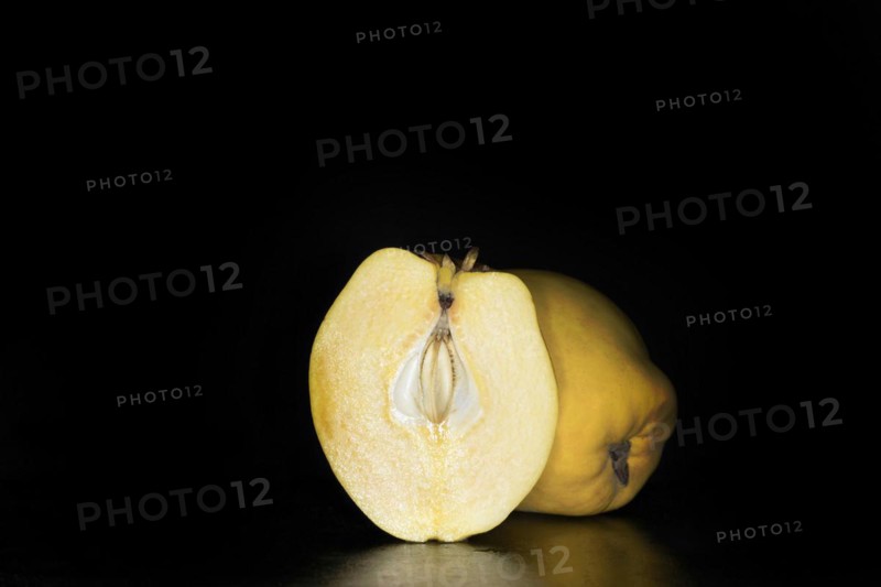 A halved and whole quince
