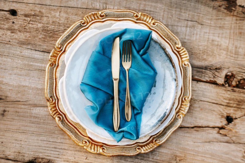 Golden and blue elegant table set on wooden background