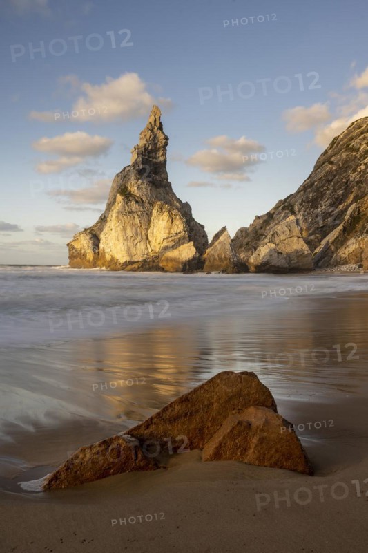 Sunset on sandy beach with rocks