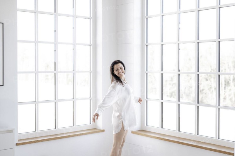 Attractive woman in a white shirt in front of a window