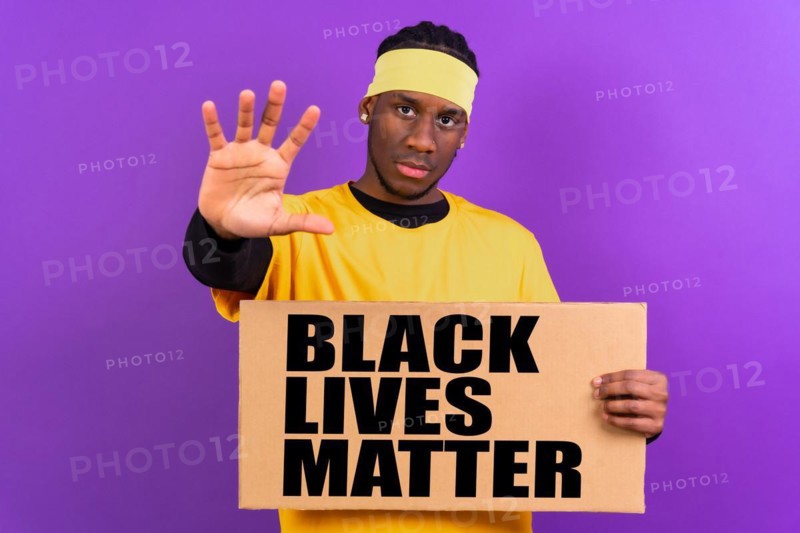 Black ethnic man in yellow clothes on a purple background