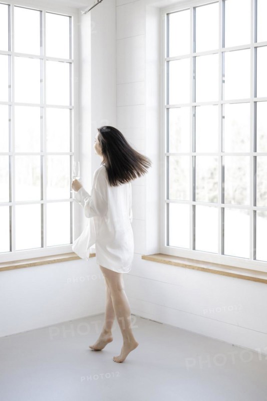Attractive woman in a white shirt in front of a window