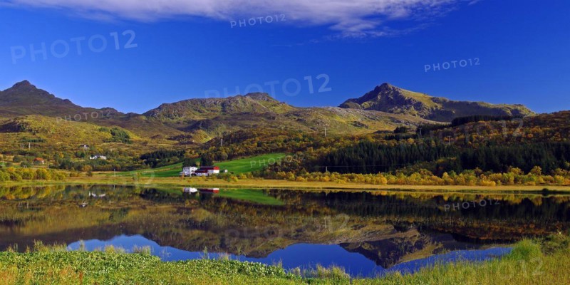 Autumn coloured forests and mountains reflected in a lake