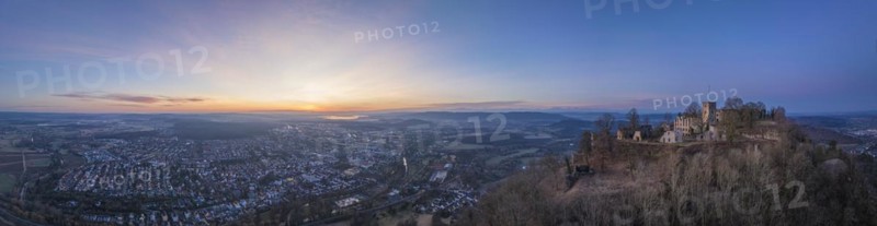 Panorama of the Hohentwiel castle ruins with the town of Singen am Hohentwiel in front of sunrise