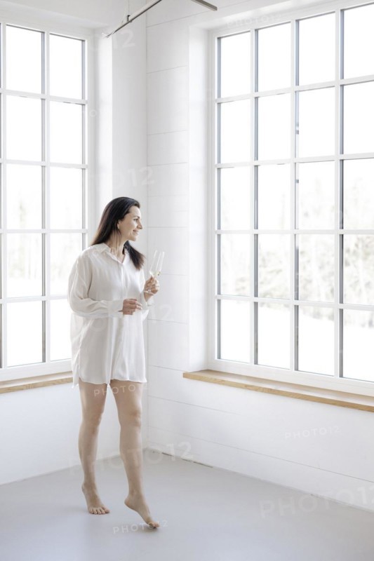 Attractive woman in a white shirt in front of a window