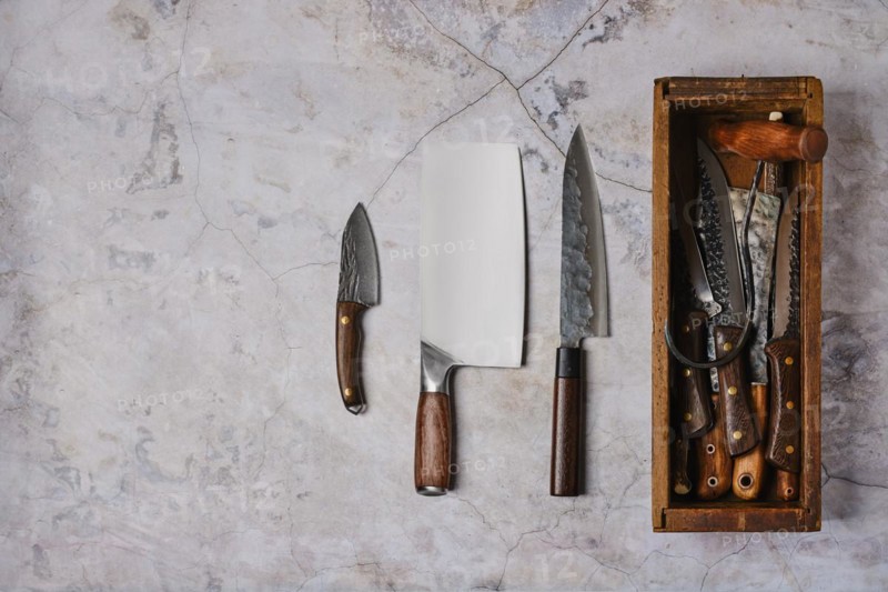 Used forged tools of butcher on stone background