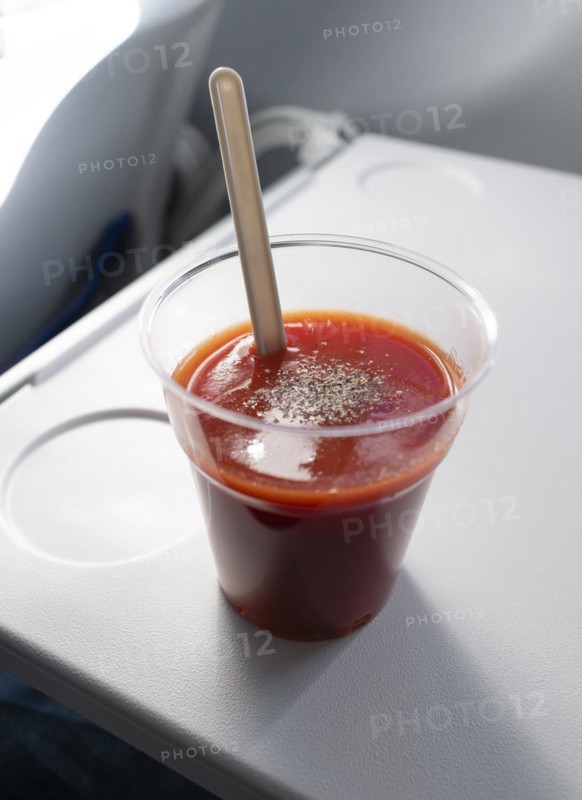 Tomato juice on a fold-out table in an aeroplane