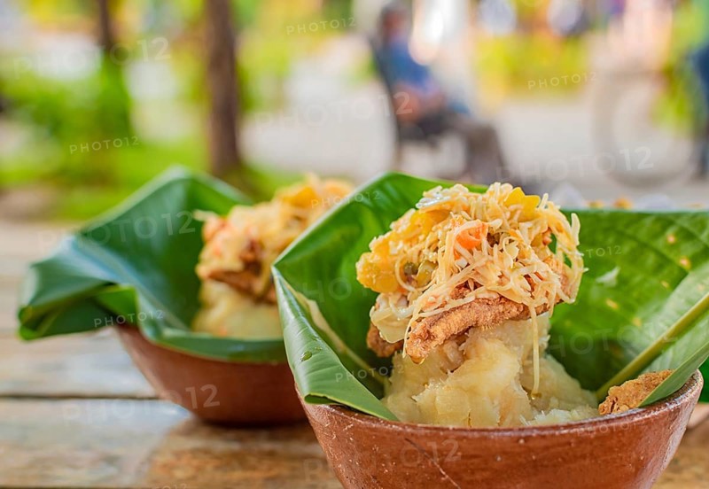 Close-up of two vigorones served on a wooden table. The vigoron typical food of Granada