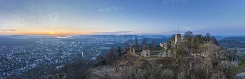 Panorama of the Hohentwiel castle ruins with the town of Singen am Hohentwiel in front of sunrise