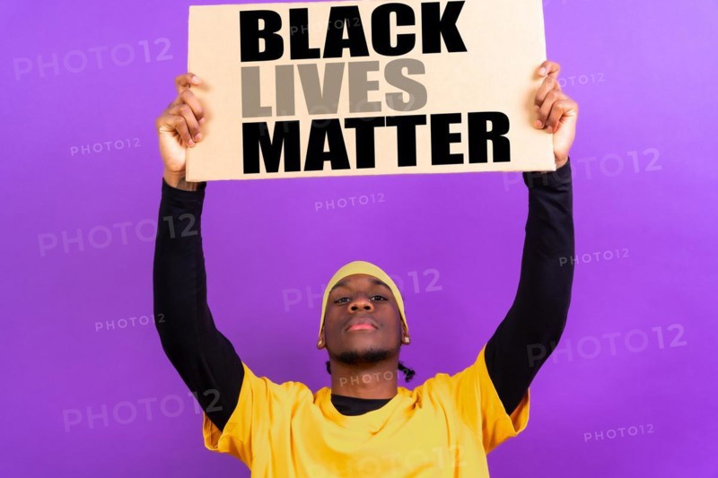 Black ethnic man in yellow clothes on a purple background