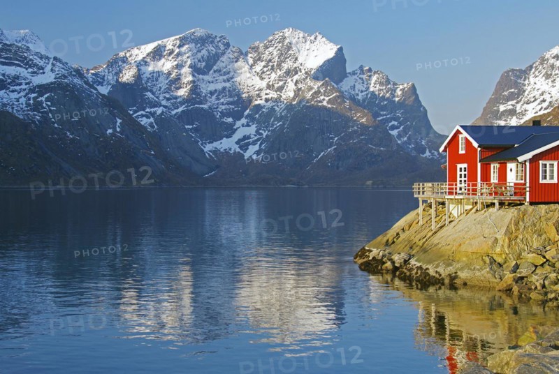 Rorbuer and high mountains reflected in a fjord