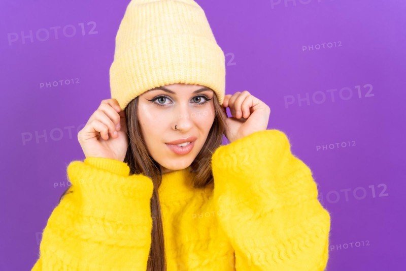 Close up portrait of young caucasian woman in yellow sweater isolated on yellow background