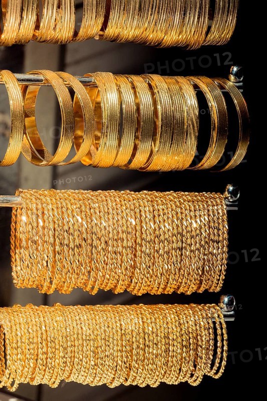 Shop display of dozens of golden bracelets and bangles