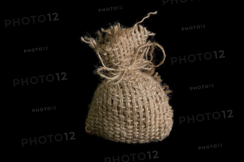 A small jute bag on a black background. In studio