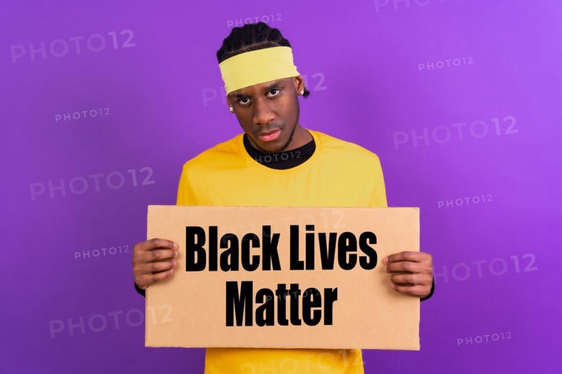 Black ethnic man in yellow clothes on a purple background