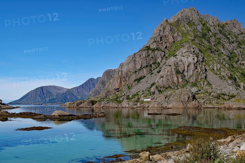 Shallow bay with crystal clear water in front of high mountain