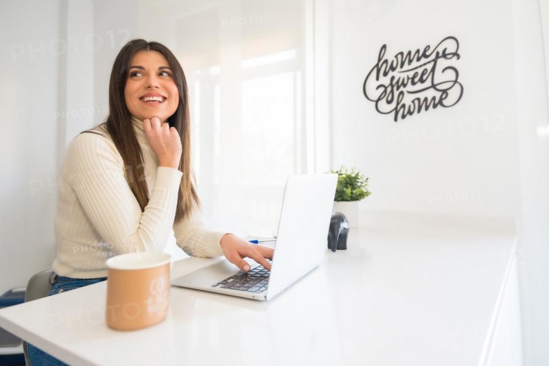 Business woman working on laptop sitting at home
