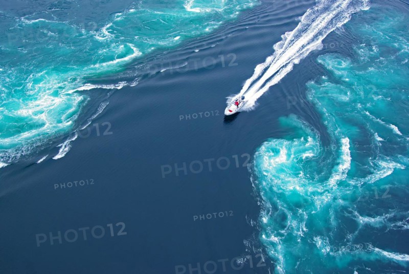 Powerboat between huge whirlpools and eddies in the water of a fjord