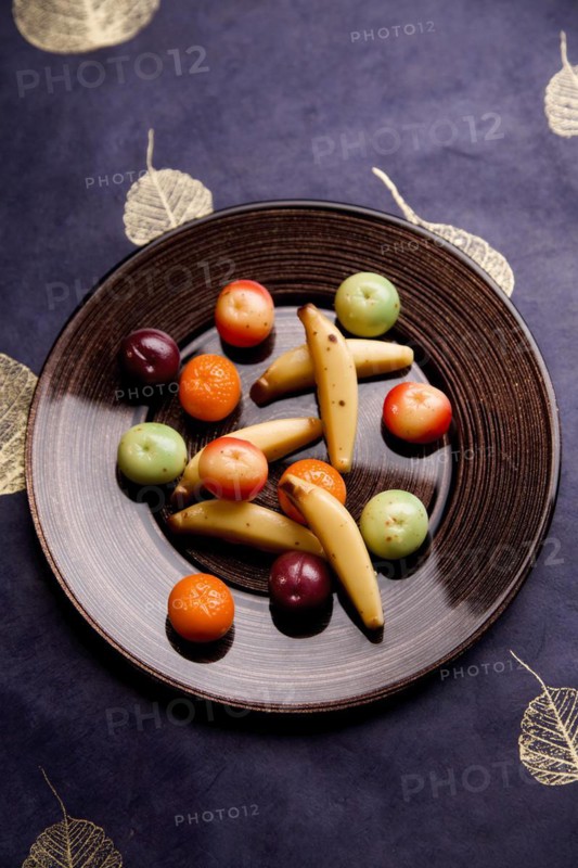 Plate with fruits made of marzipan on a blue blanket