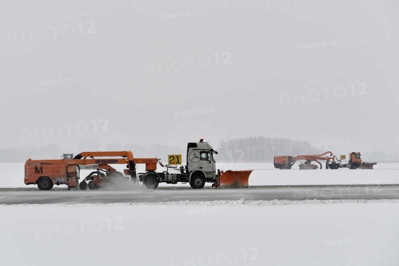 Road sweepers and snow ploughs clear snow on the taxiways and Runway North