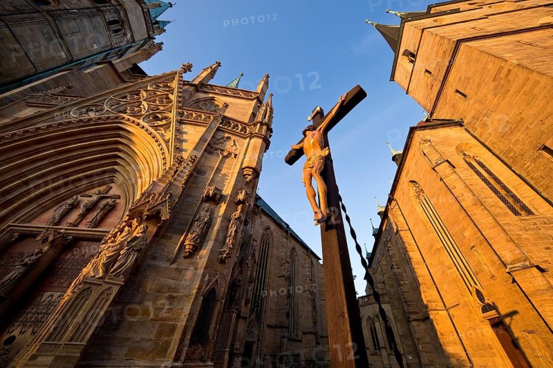 Jesus Christ on the cross between Erfurt Cathedral and Severi Church in early morning light