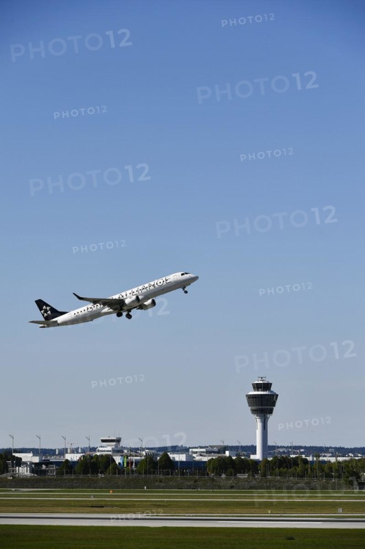 Taking off Star Alliance AIR DOLOMITI EMBRAER ERJ-195 on runway south with tower