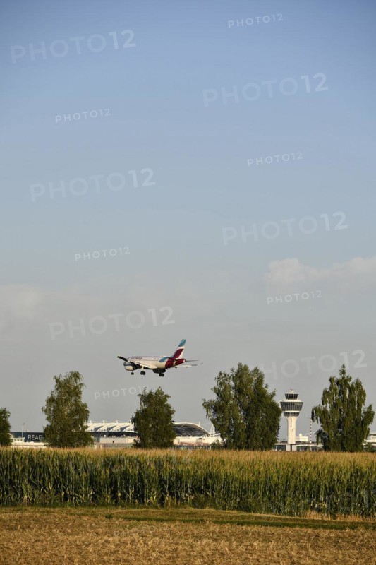 Eurowings Airbus A320 landing on Runway North with Tower Munich Airport and cornfield in the foreground
