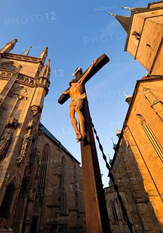 Jesus Christ on the cross between Erfurt Cathedral and Severi Church in early morning light