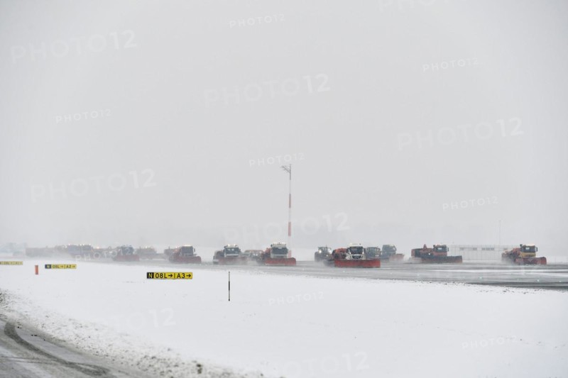 Road sweepers and snow ploughs clear snow on the taxiways and Runway North