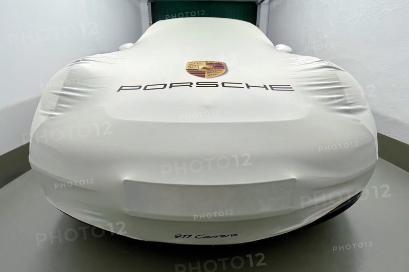 Perspective dynamic photo of sports car Porsche 911 Carrera in garage with protective cover indoor bonnet protective cover with on it logo company logo coat of arms lettering brand name